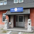 Asia World Nienburg Eingangsbereich des Asia World Nienburg mit zwei steinernen Wächterlöwen und Backsteinfassade.