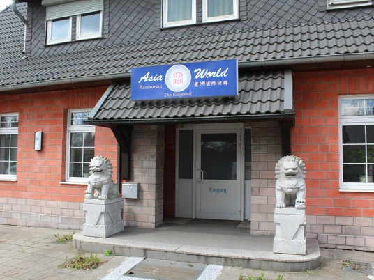 Asia World Nienburg Eingangsbereich des Asia World Nienburg mit zwei steinernen Wächterlöwen und Backsteinfassade.