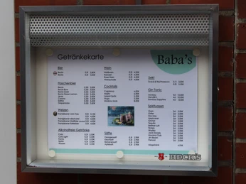 Baba´s Bistro Die Getränkekarte von Baba's Bistro, befestigt an einer roten Ziegelwand, wird präsentiert.