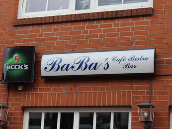 Baba´s Bistro Baba's Bistro mit einladendem Eingang im Backsteingebäude, flankiert von Laternen und Bierschild.
