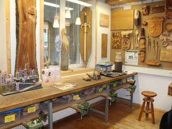 Holzwerkstatt mit Werkbank, Werkzeugen und hölzernen Kunstwerken an den Wänden, inklusive Modellbau.Wood workshop with workbench, tools and wooden works of art on the walls, including model making.Træværksted med arbejdsbænk, værktøj og kunstværker i træ på væggene, herunder modelbygning.Houtwerkplaats met werkbank, gereedschap en houten kunstwerken aan de muren, inclusief modelbouw.