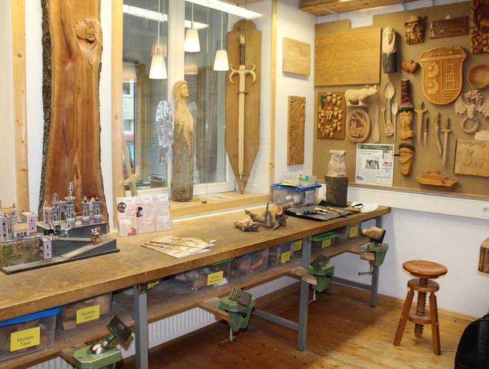KreativWerkstatt am Wall Holzwerkstatt mit Werkbank, Werkzeugen und hölzernen Kunstwerken an den Wänden, inklusive Modellbau.Wood workshop with workbench, tools and wooden works of art on the walls, including model making.Træværksted med arbejdsbænk, værktøj og kunstværker i træ på væggene, herunder modelbygning.Houtwerkplaats met werkbank, gereedschap en houten kunstwerken aan de muren, inclusief modelbouw.