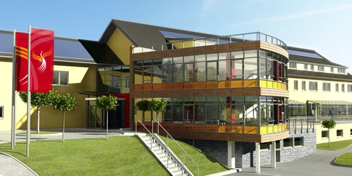 Außenansicht Moderner Bürokomplex mit Glasfassade und roten Akzenten, umgeben von gepflegten Rasenflächen.