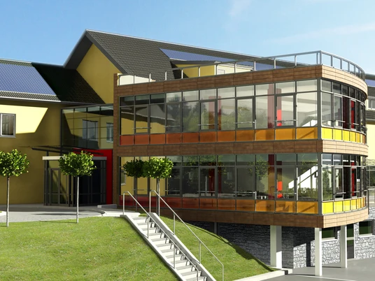 Außenansicht Moderner Bürokomplex mit Glasfassade und roten Akzenten, umgeben von gepflegten Rasenflächen.