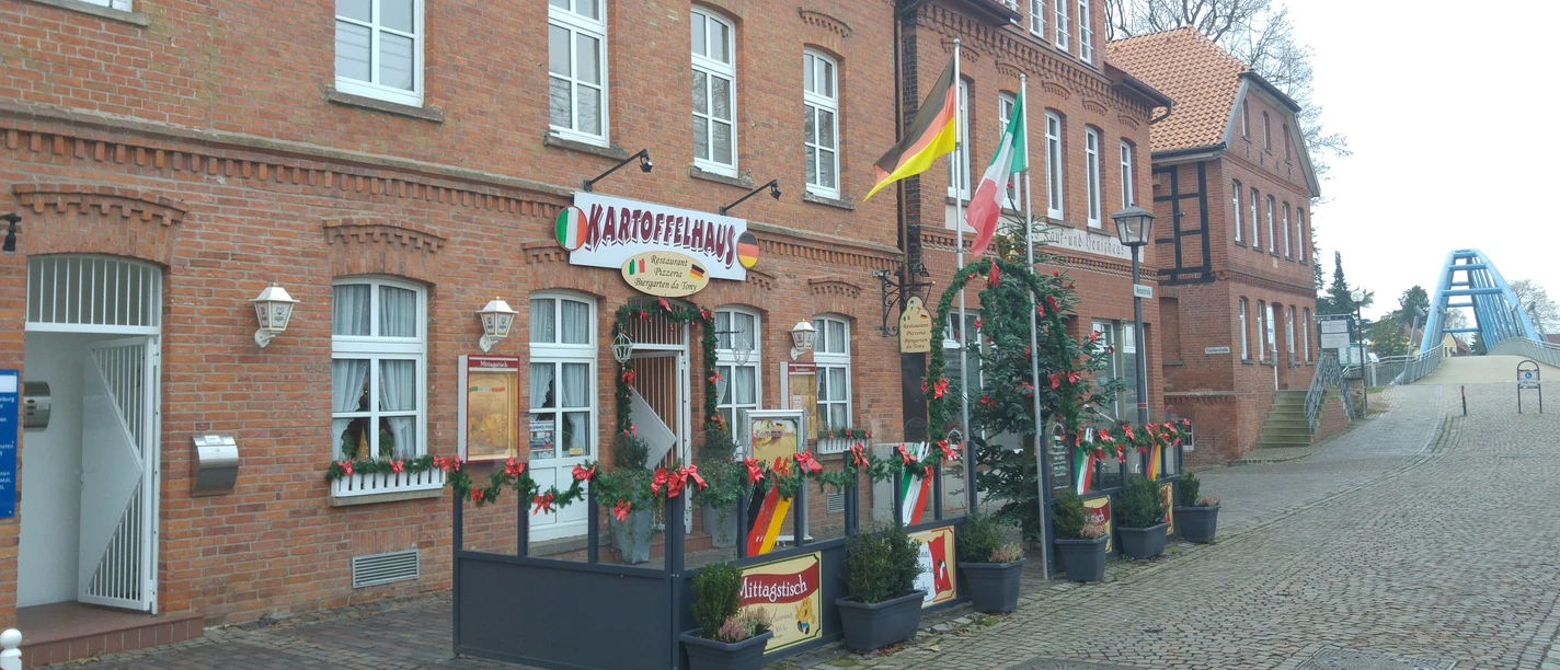 The red-brick potato house with inviting terrace, festively decorated for the Christmas season.