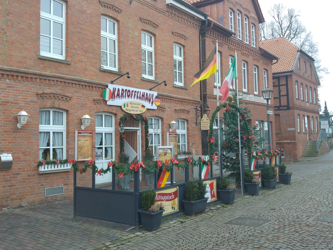 Kartoffelhaus Das Kartoffelhaus aus rotem Backstein mit einladender Terrasse, festlich geschmückt zur Weihnachtszeit.The red-brick potato house with inviting terrace, festively decorated for the Christmas season.Kartoffelhuset i røde mursten med den indbydende terrasse er festligt pyntet op til jul.Het rode bakstenen aardappelhuisje met uitnodigend terras is feestelijk versierd voor Kerstmis.