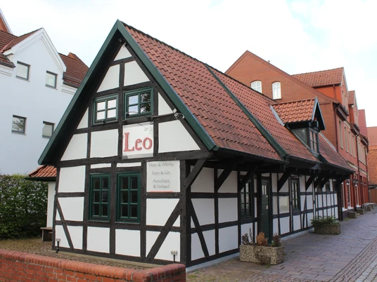 Ein traditionelles Fachwerkgebäude mit rotem Ziegeldach und der Aufschrift "Leo" an der Fassade.