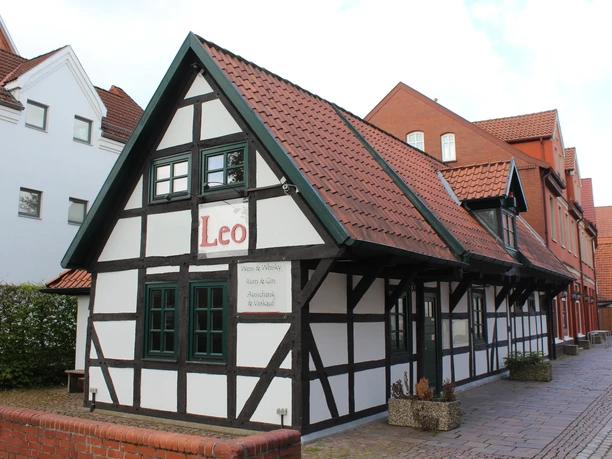 A traditional half-timbered building with a red tiled roof and the inscription "Leo" on the façade.