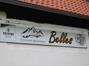 Ein Schild mit der Aufschrift "Belles" und "Griechische Spezialitäten" sowie Logos von Veltins und Maisel's Weisse.A sign with the words "Belles" and "Greek specialties" as well as logos of Veltins and Maisel's Weisse.Et skilt med ordene "Belles" og "Greek specialities" samt logoerne for Veltins og Maisel's Weisse.Een bord met de woorden "Belles" en "Griekse specialiteiten" en de logo's van Veltins en Maisel's Weisse.