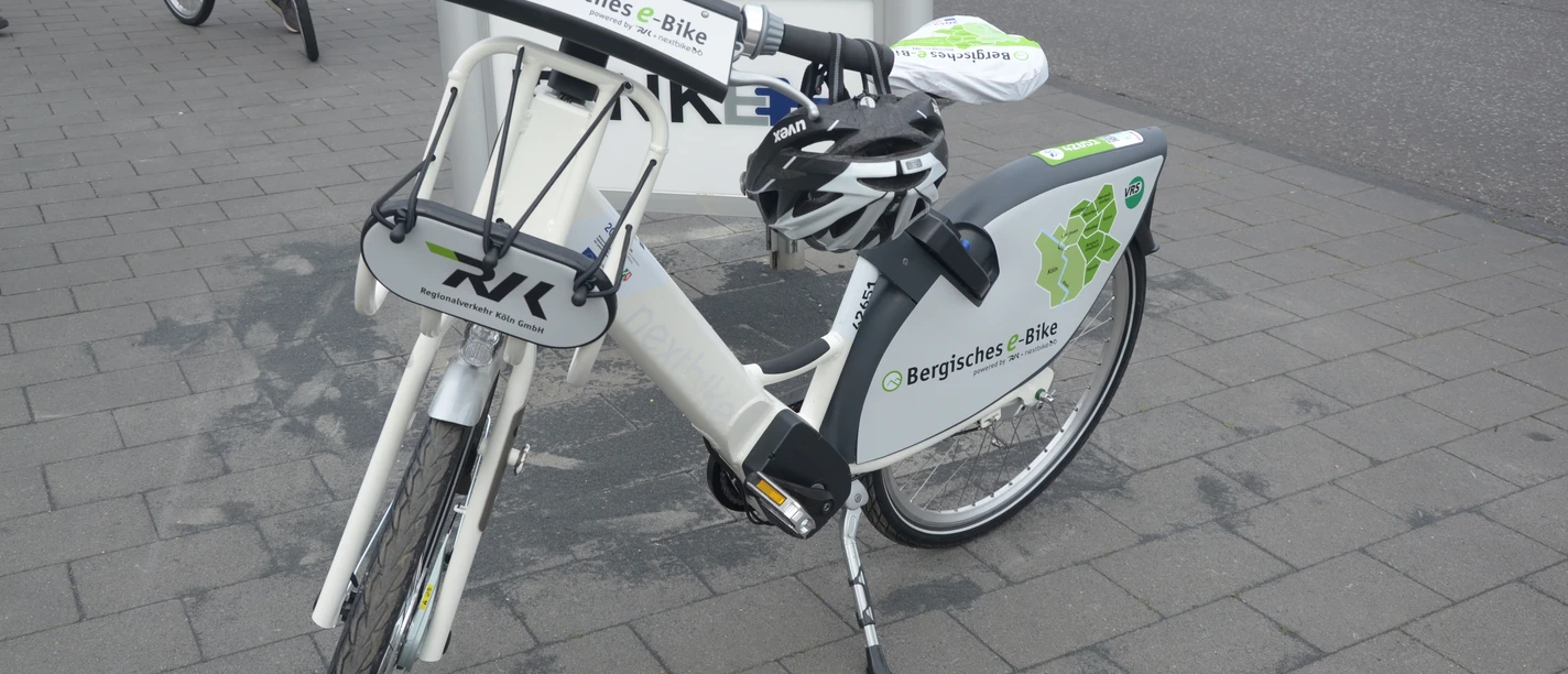 Bergisches E-Bike Elektrofahrrad mit weißem Rahmen, ausgestattet für Verleih Bergisches e-Bike, auf gepflastertem Boden.