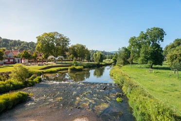 Emmerauenpark mit Emmer in Lügde Fluss Emmer fließt durch Emmerauenpark in Lügde, umgeben von grünen Wiesen und Bäumen.