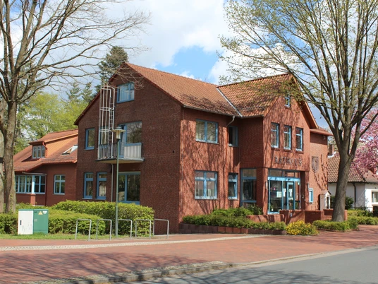 Rathaus Eystrup Backsteinbau des Rathaus Eystrup in Niedersachsen mit grünem Umfeld und blauem Himmel im Hintergrund.