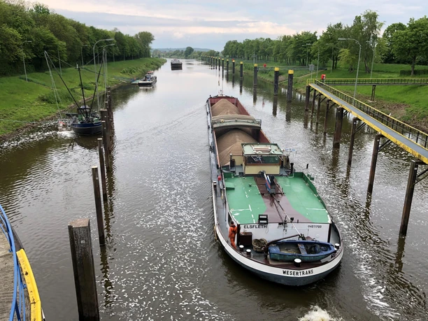 Schleuse Landesbergen Frachtschiff durchquert die Schleuse Landesbergen auf der Weser, umgeben von grünen Ufern und Schiffen.