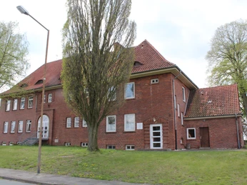 Stadtarchiv Petershagen Backsteingebäude des Stadtarchivs Petershagen mit rotem Ziegeldach und umliegenden Bäumen.