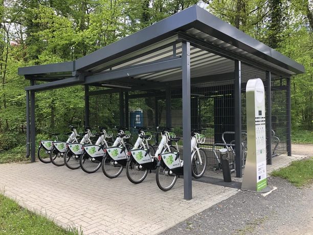 Mobilstation Altenberg Überdachte Fahrradstation im Grünen mit Fahrrädern zur Ausleihe und einem Terminal zur Anmeldung.