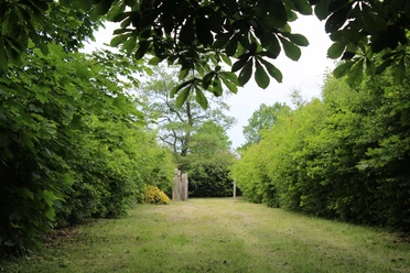 Der Jüdische Friedhof Lavelsloh ist umgeben von dichtem Grün und bietet eine ruhige Atmosphäre.