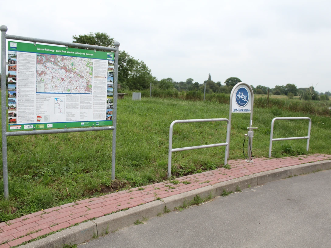 Lufttankstelle Weyhe/Dreye Eine Lufttankstelle für Fahrräder mit einer Informationskarte umgeben von grüner Landschaft.