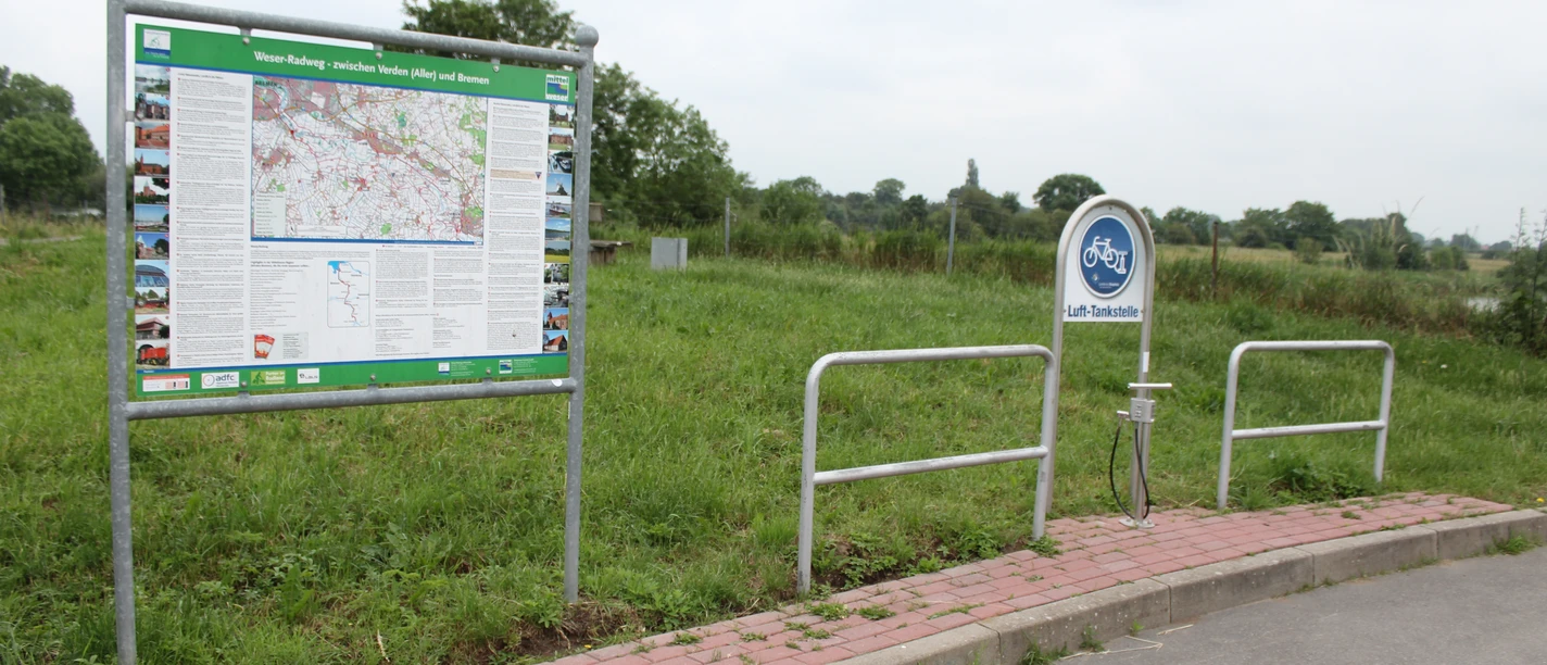 Lufttankstelle Weyhe/Dreye Eine Lufttankstelle für Fahrräder mit einer Informationskarte umgeben von grüner Landschaft.
