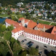 Schloss Iburg aus der Vogelperspektive Luftaufnahme eines historischen Schlosses mit rotem Dach, umgeben von Wohnhäusern und Grünflächen.Aerial view of a historic castle with a red roof, surrounded by residential buildings and green spaces.Luftfoto af et historisk slot med rødt tag, omgivet af beboelsesejendomme og grønne områder.Luchtfoto van een historisch kasteel met een rood dak, omringd door woongebouwen en groene ruimtes.