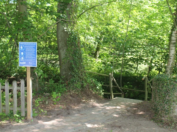 The path to the Wietzen Kneipp facility leads through a natural trail surrounded by trees.