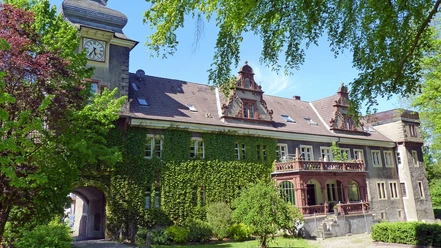 Das historische Schloß Mühlenburg mit Efeu bewachsenen Mauern und prunkvollen Giebeln bei Sonnenschein.