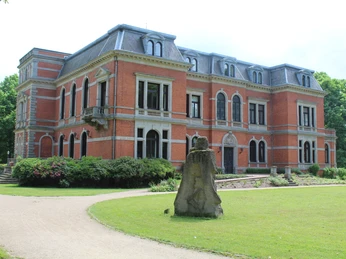 Schloss Etelsen mit Skulptur "Kopfgeburt" Schloss Etelsen erhebt sich majestätisch mit der Skulptur "Kopfgeburt" im gepflegten Parkgelände.