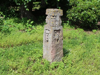 Skulptur im Park Etelsen "und ich war auch hier" Steinskulptur im Park Etelsen, umgeben von grüner Vegetation, zeigt Gravuren und verwitterte Details.