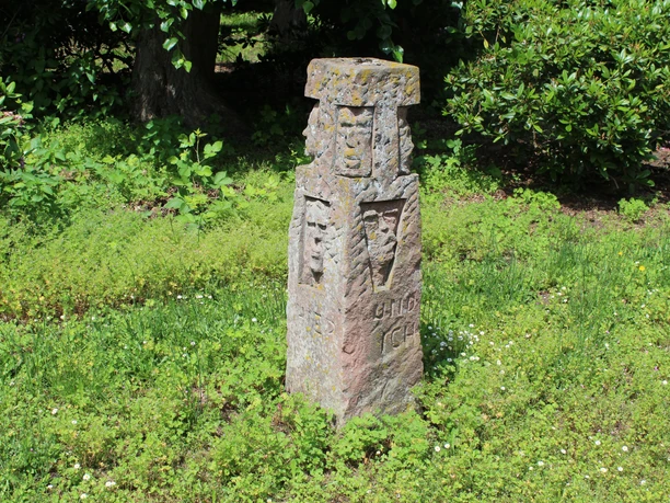 Skulptur im Park Etelsen "und ich war auch hier" Steinskulptur im Park Etelsen, umgeben von grüner Vegetation, zeigt Gravuren und verwitterte Details.
