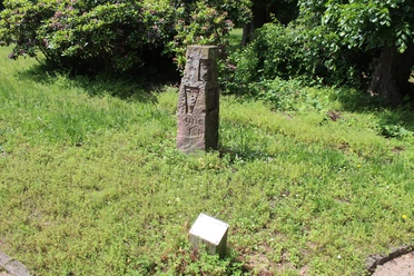 Skulptur im Park Etelsen "und ich war auch hier" Steinmonument im Grünen mit Inschrift "und ich war auch hier", umgeben von Pflanzen im Park Etelsen.