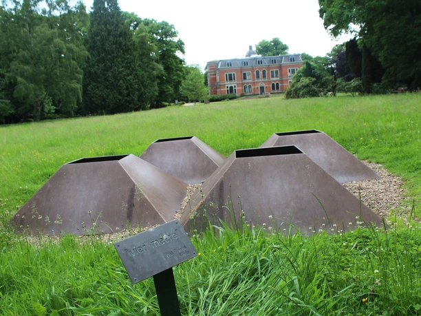 Skulpture im Park Etelsen "vier meere" Vier rostige Metallskulpturen in einer Rasenfläche im Park Etelsen, mit einem historischen Gebäude im Hintergrund.