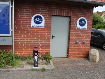 Lufttankstelle Asendorf Eine öffentlich zugängliche Lufttankstelle für Fahrräder an einer Klinkerwand, ausgestattet mit Werkzeug.