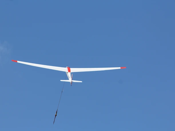 Segelflugzeug in der Luft gegen klaren blauen Himmel beim Start am Segelflugplatz Hoya.