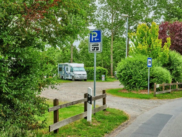 Wohnmobilstellplatz Bentwisch Oberndorf Von Bäumen gerahmter Wohnmobilstellplatz mit Reisemobil und Schild.