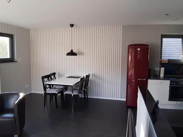 20210602_192533_Essbereich.jpg Moderner, offener Wohn-Essbereich mit rotem Retro-Kühlschrank, Esstisch, schwarzem Ledersessel.