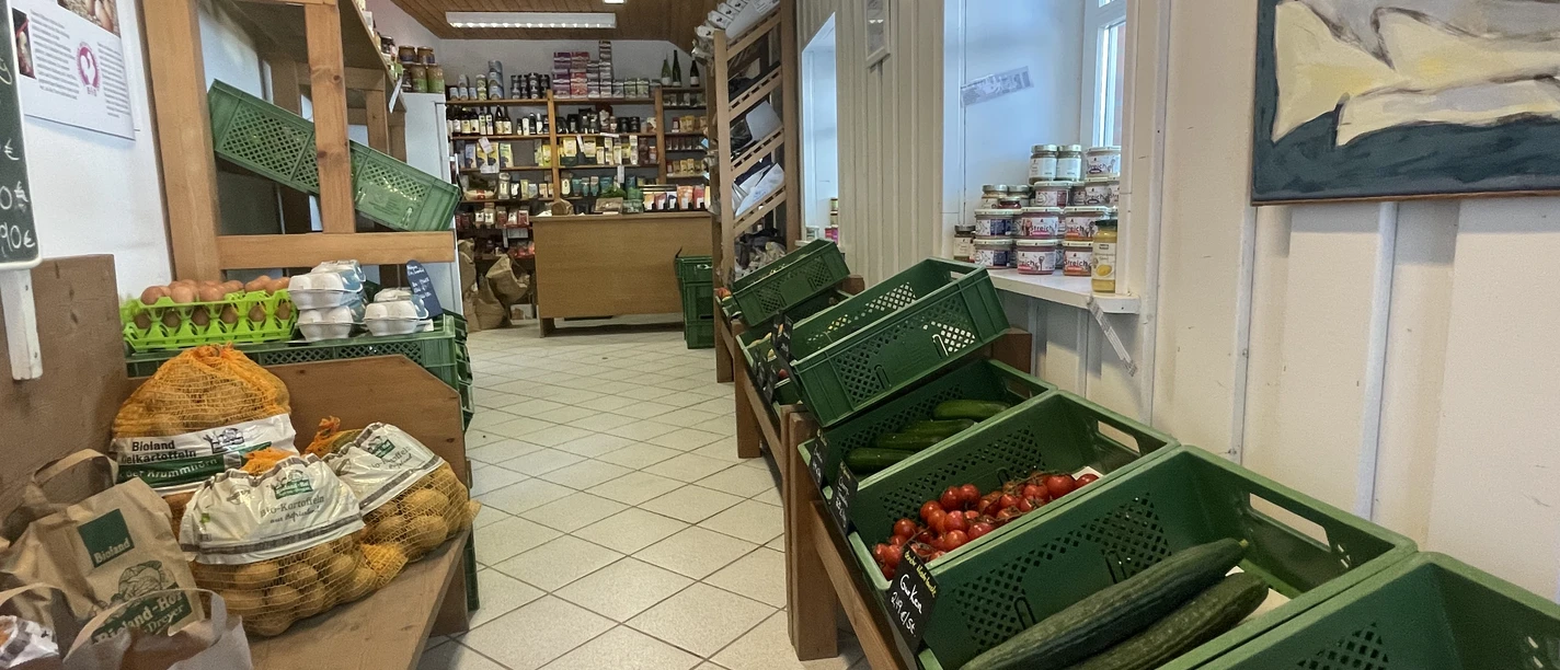Biolandhof Agena-Dreyer Regale eines Hofladens mit frischem Gemüse, Eiern, Kartoffeln und regionalen Bioprodukten.