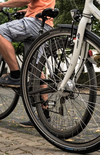 Rad fahren in Altenberg Zwei Personen auf Fahrrädern fahren auf einem gepflasterten Weg vor einem historischen Gebäude.