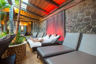 Teutoburger Wald-2015-Wellness-001-Teutoburger-Wald-Tourismus-D-Ketz.jpg Zwei Personen in weißen Bademänteln entspannen auf Liegen in einem eleganten, gemütlichen Wellnessbereich.