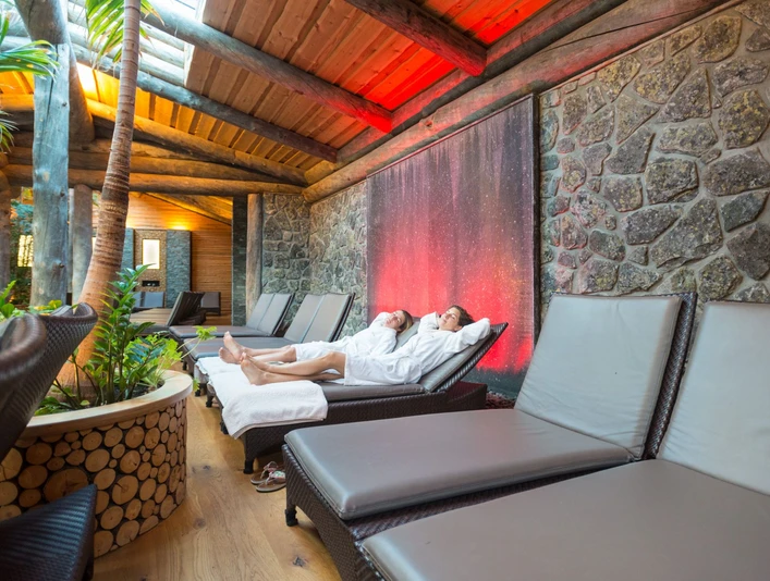 Teutoburger Wald-2015-Wellness-001-Teutoburger-Wald-Tourismus-D-Ketz.jpg Zwei Personen in weißen Bademänteln entspannen auf Liegen in einem eleganten, gemütlichen Wellnessbereich.