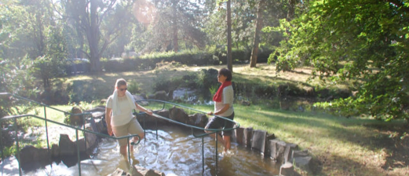 Wassertreten Habichtswaldklinik Zwei Personen sind am Wassertreten bei der Kneippanlage an der Habichtswaldklinik.