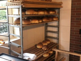 Stuten in Reih und Glied Frisch gebackene Laibe Stuten auf einem drei Ebenen hohen Holzregal