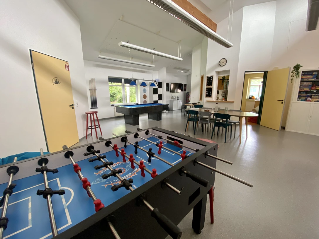 CASA Jugendraum Der CASA Jugendraum zeigt einen hellen Raum mit Fußballtisch, Billardtisch und Sitzgruppe. Perfekt für Jugendliche.