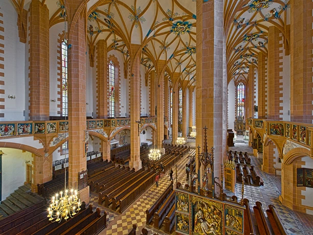 View of the interior of Annaberg St. Anne's Church with high columns and richly decorated balconies.
