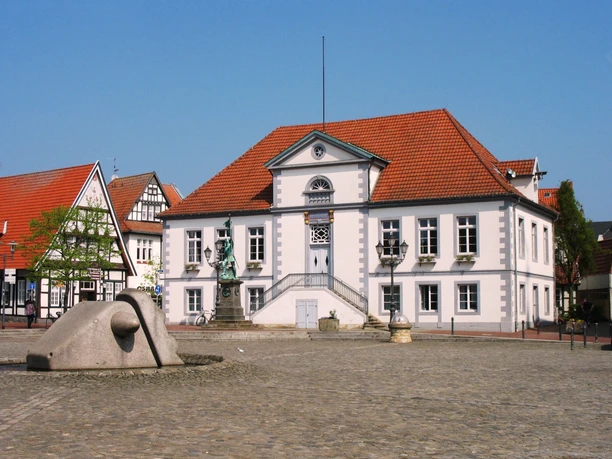 Marktplatz Quakenbrück Historisches Rathaus auf dem Marktplatz von Lingen mit Statue und Brunnen im Vordergrund.