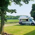 Wohnmobilstellplatz Lüttsche-Hoff Wohnmobil auf grünem Platz am Feldrand, umgeben von Bäumen und ländlicher Natur.