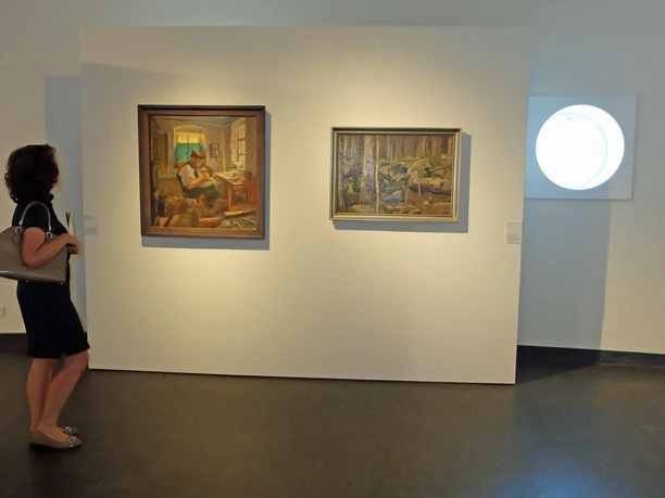 OL_Goerlitz_KultHistMus_WG_DSCF0161.JPG Eine Frau betrachtet zwei Gemälde in einem Museum. Die Umgebung wirkt modern und minimalistisch.