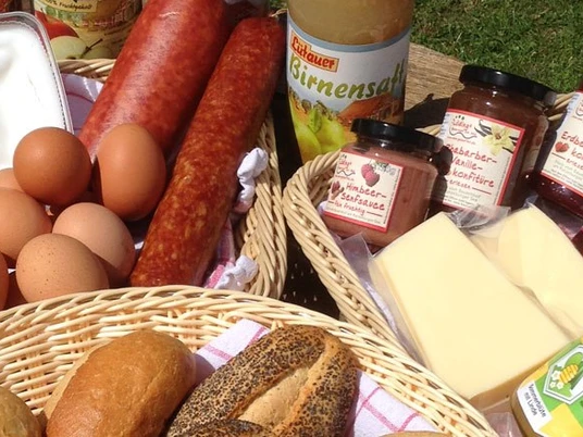 Körbe eines Frühstückbüffets Flechtkörbe mit Frühstückszutaten wie Brötchen, Wurst und Eiern