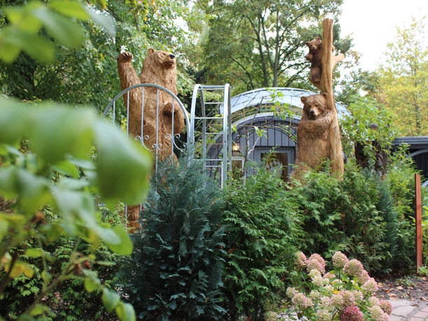 Bärenskulptur Nienburg Holzbärenskulpturen stehen zwischen naturbelassenem Grün in einer parkähnlichen Umgebung in Nienburg.