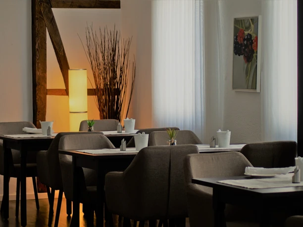 Zum Schwanen Gemütliche Restaurant-Inneneinrichtung mit gedeckten Tischen, Holzdetails und gedämpftem Licht.