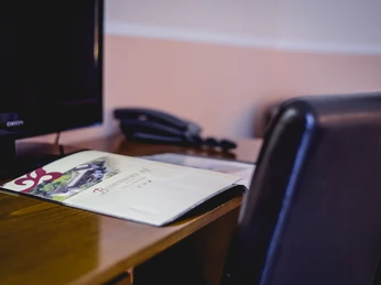 Bierenbacher Hof Ein Schreibtisch mit Unterlagen, Telefon und Monitor, bereit für Gäste in gepflegtem Ambiente.