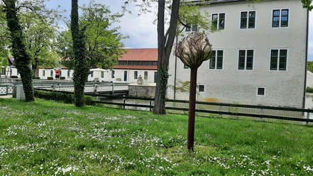 Schloss Benkhausen Skulptur im Park des Schlosses Benkhausen, umgeben von grüner Wiese und blühenden Bäumen.